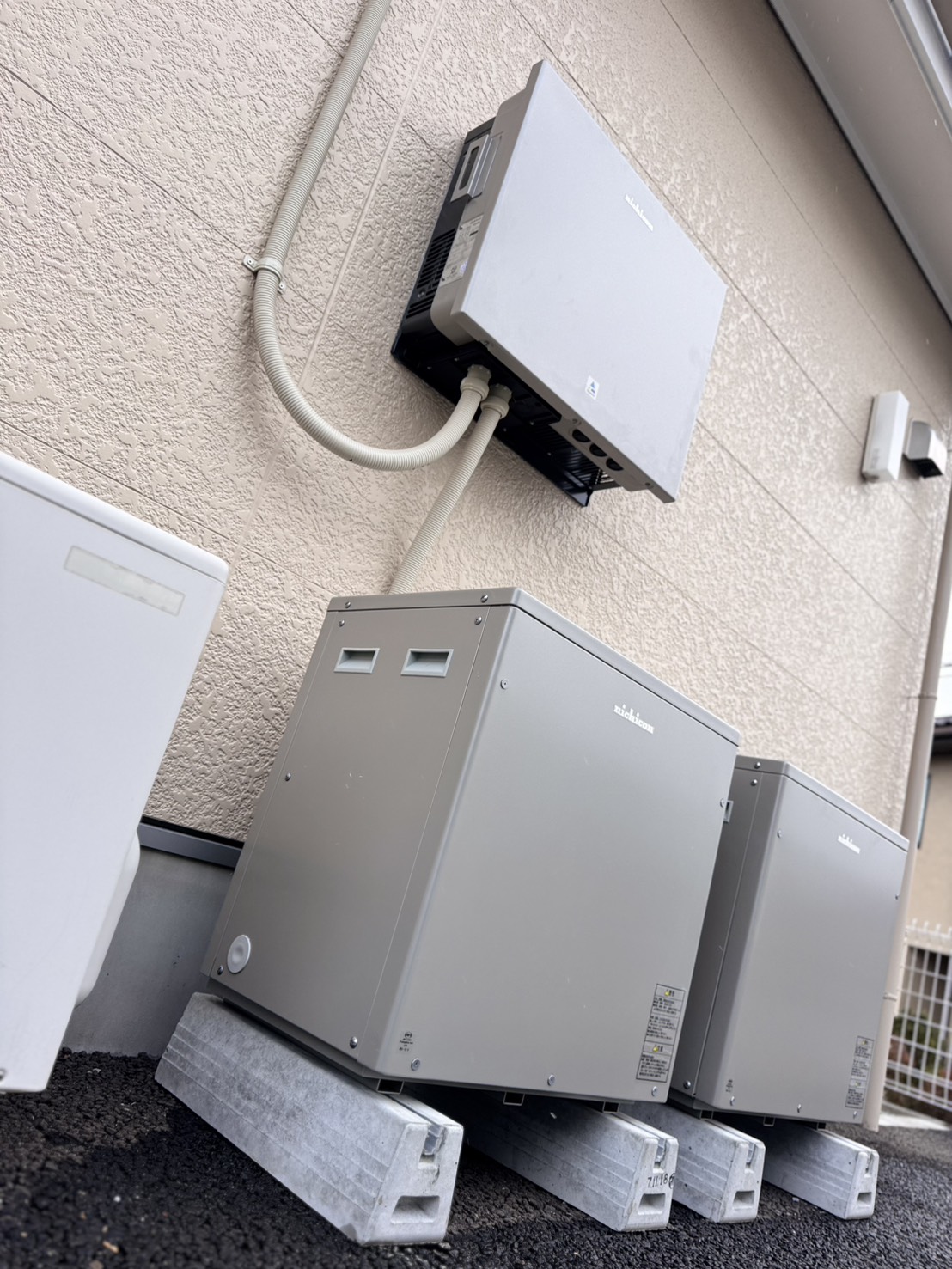 屋外に設置された蓄電池2台とパワーコンディショナ。基礎ブロックで高さを確保