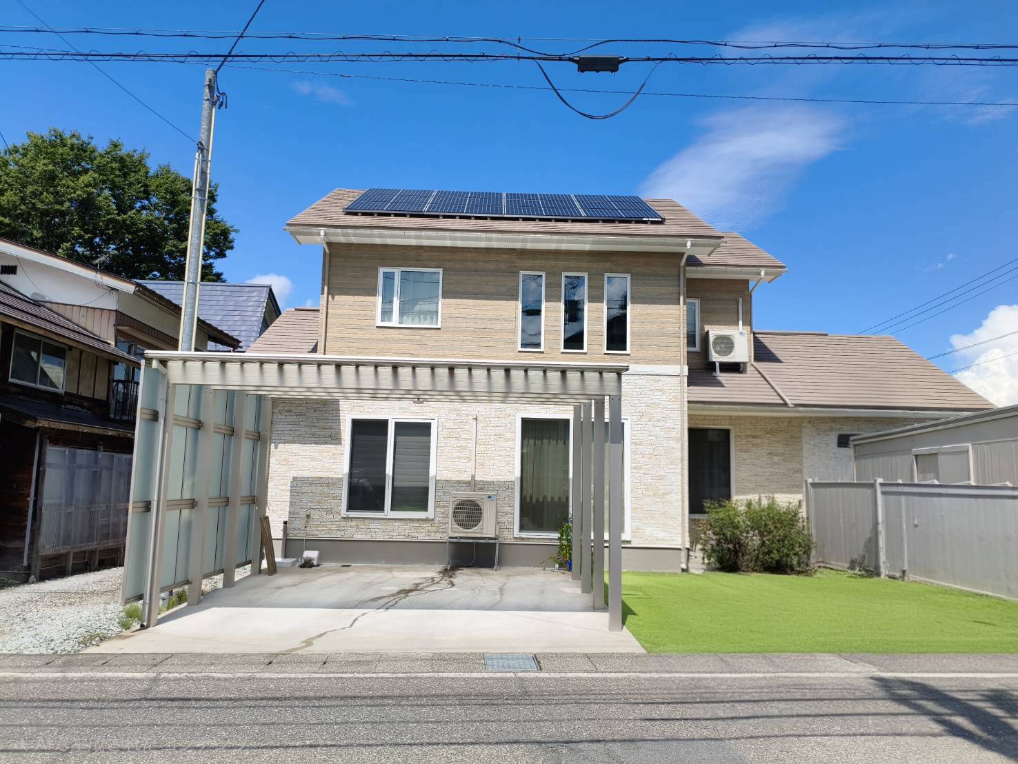 屋根に太陽光パネルを設置した戸建住宅の外観とカーポート