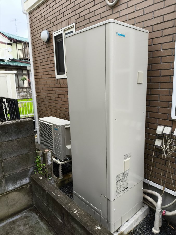 ブロック塀の上に設置したエコキュートの貯湯タンク